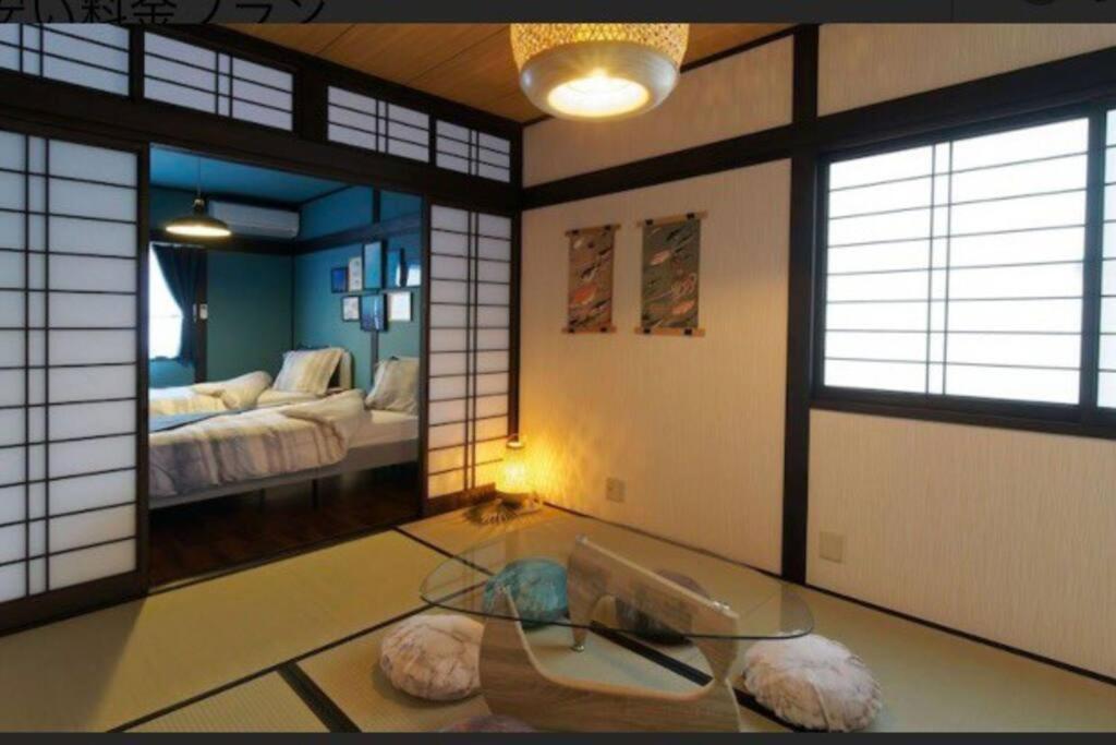 高松市にある民宿　setouchiのガラスのテーブル付きの部屋、ベッド付きの部屋