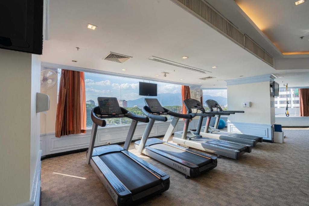 A window-lined cardio area with several treadmills and a mountain-facing outlook.