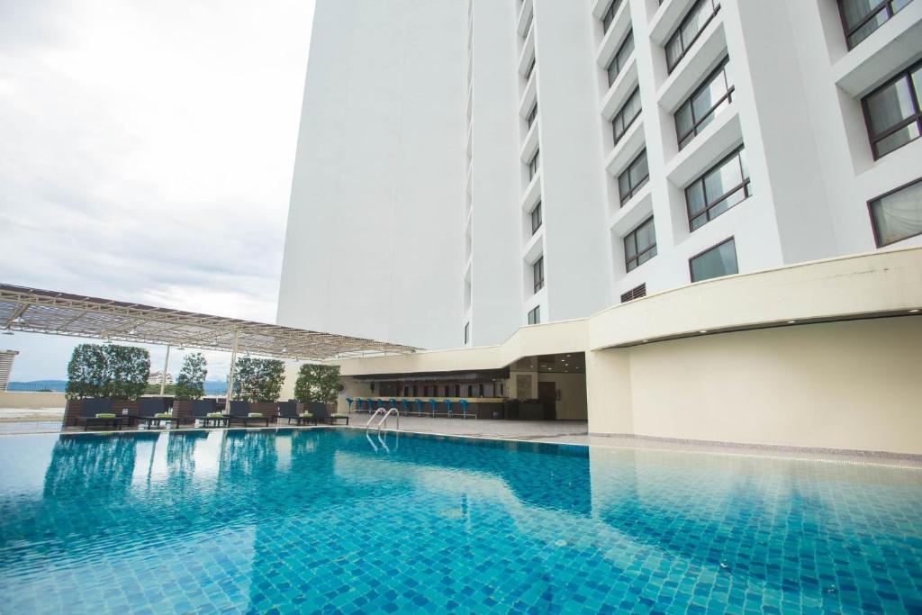 A blue-tiled outdoor pool set directly beside the hotel building.