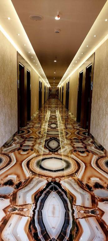 a hallway of a hotel with a marble floor at Hotel Madhuban in Silvassa