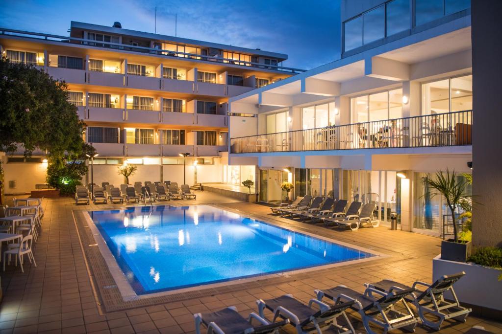 uma piscina em frente a um edifício em Hotel Londres Estoril / Cascais em Estoril