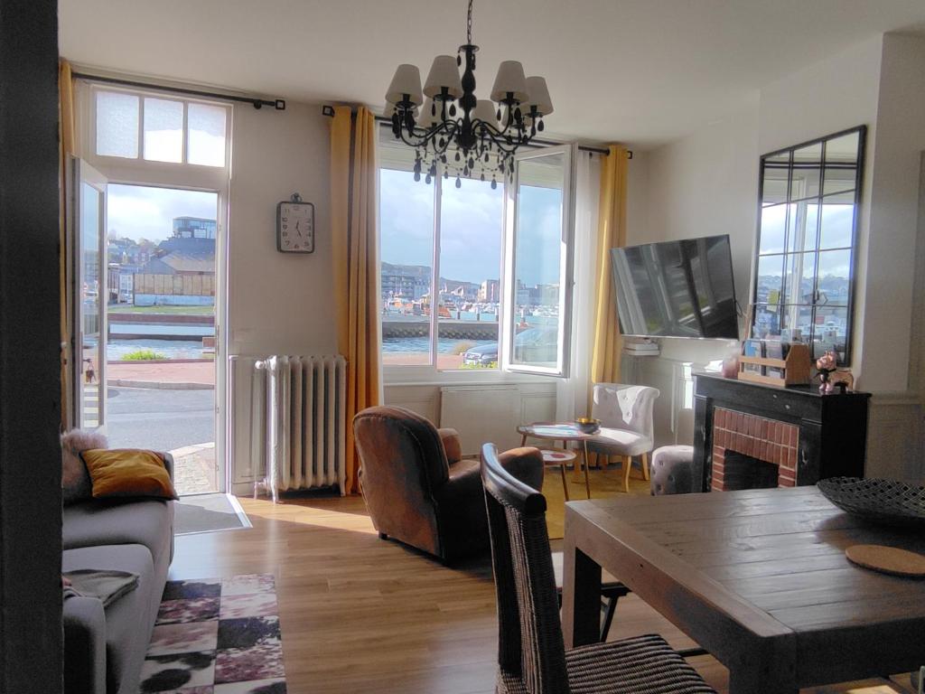 a living room with a table and a living room with a view at LE WELCOME vue port appartement plain pied in Fécamp