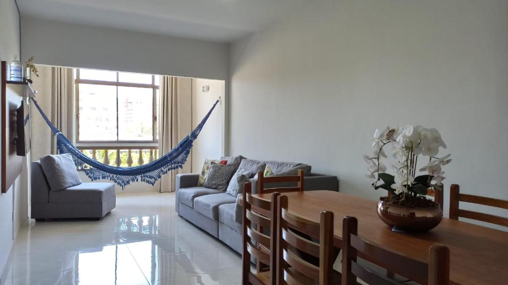 ein Wohnzimmer mit einem Sofa und einem Tisch in der Unterkunft Apto a 3 minutos Praia da Pontinha na Lagoa de Araruama in Araruama
