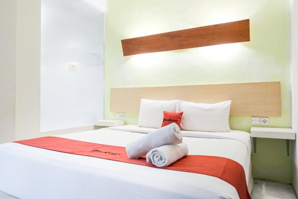 a bedroom with a bed with two pillows on it at RedDoorz Plus at Sunrise Hotel Sanur in Sanur