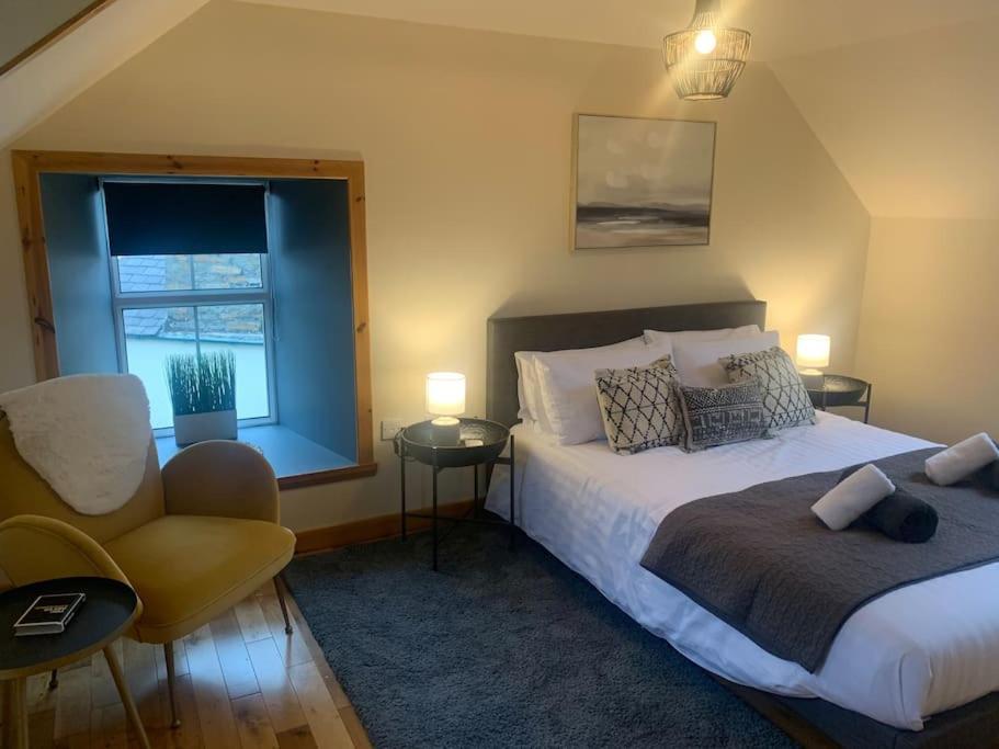 a bedroom with a bed and a chair and a window at Orkney Staycations - Orcadale in Orkney
