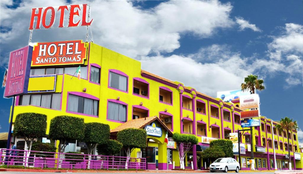 a hotel with a yellow and pink building at Hotel Santo Tomas in Ensenada