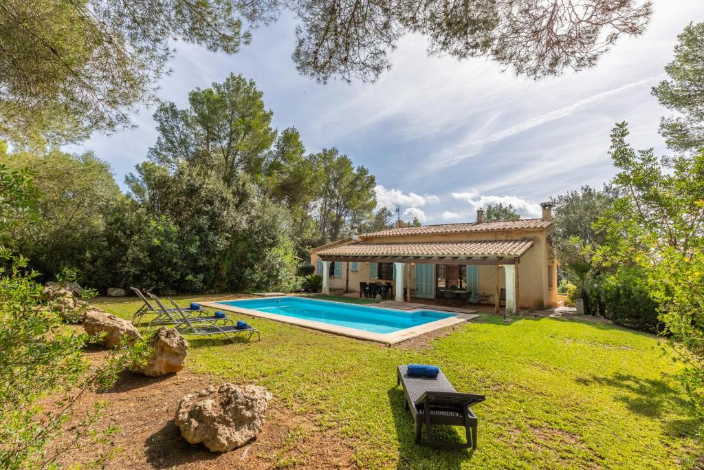 a house with a swimming pool in a yard at Villa Mireia in Pollença