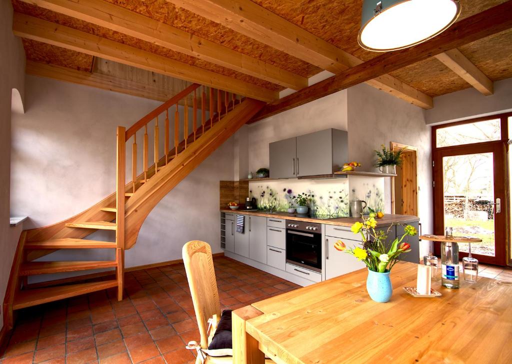una cocina con una mesa de madera y una escalera en Ferienwohnung Bolbritz en Bautzen