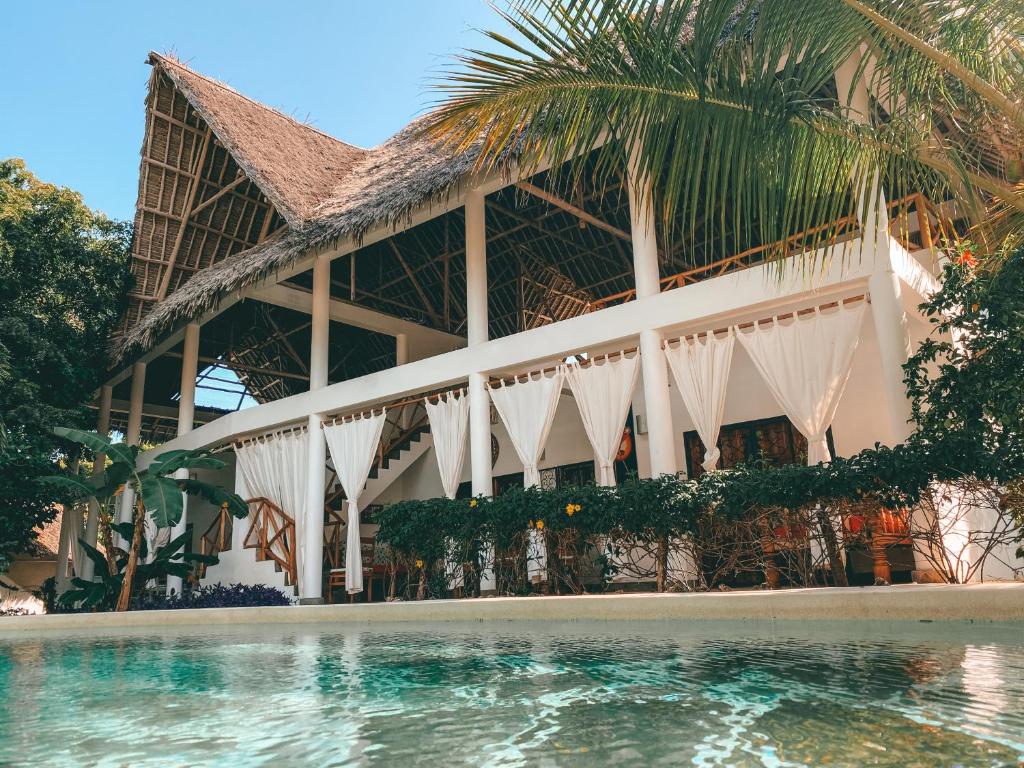 a resort with a swimming pool in front of a building at Villa Samawati - Rafiki Village in Watamu