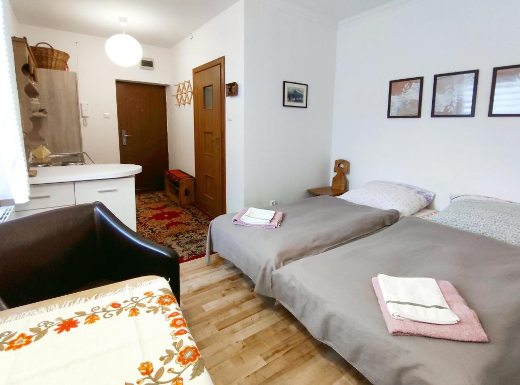 sypialnia z 2 łóżkami i kuchnia ze zlewem w obiekcie Apartament Alpejski Mały w mieście Lądek-Zdrój