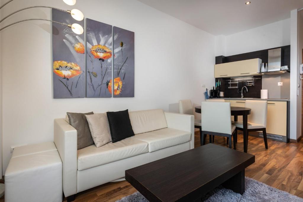 a living room with a white couch and a table at TATRYSTAY Oliver Apartments in Štrbské Pleso