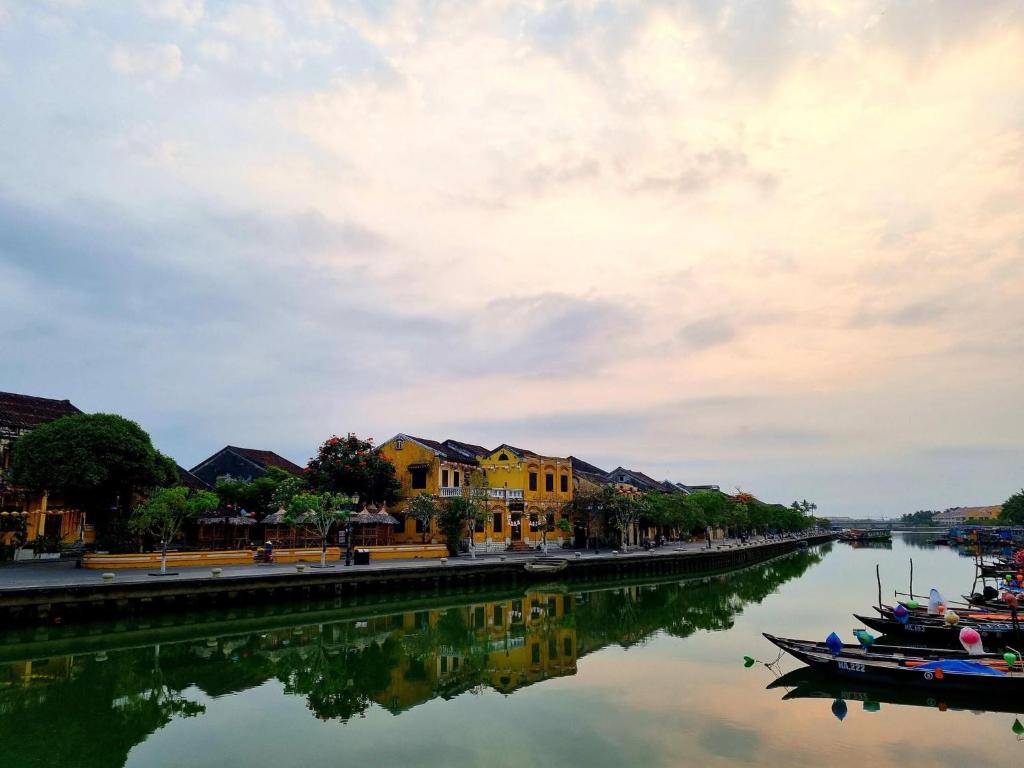 a river with houses and boats in the water at hoi an center town in Hoi An