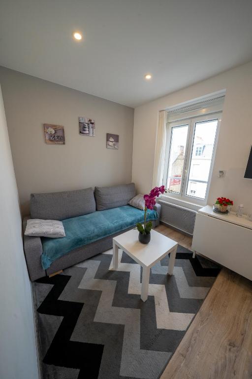 un salon avec un canapé et une table dans l'établissement La merveille de Rochebonne 2, à Saint-Malo