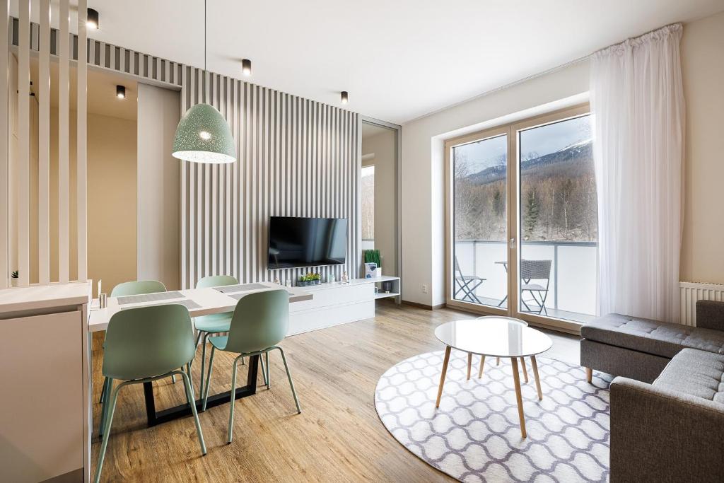 a living room with a table and chairs at TATRYSTAY Bernard Apartments in Vysoke Tatry - Novy Smokovec