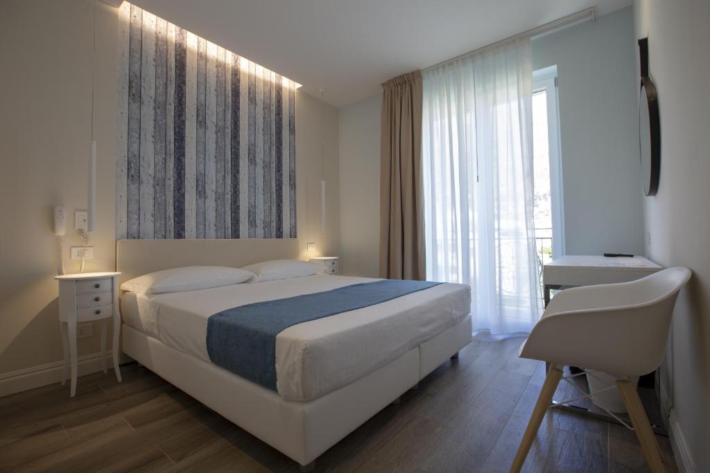 a bedroom with a large bed and a window at Luxmarì Hotel & Spa in Castellammare del Golfo
