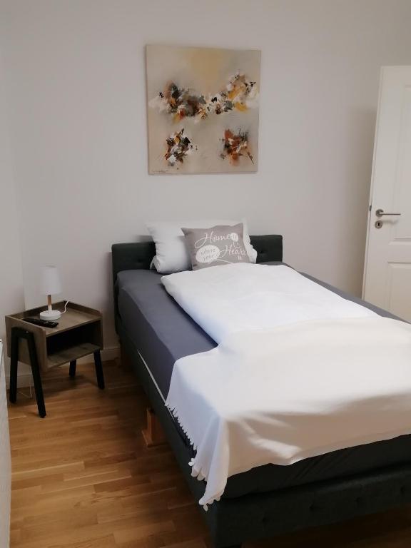 Schlafzimmer mit einem Bett und einem Beistelltisch in der Unterkunft AufmLohr - Appartement mit 3 Schlafzimmern - in Leverkusen Hitdorf - Private Parkplätze vorhanden- in Leverkusen