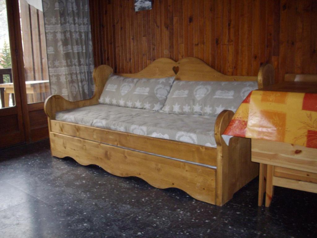 a wooden bed in a room with a table at Studio Valloire, 1 pièce, 4 personnes - FR-1-263-55 in Valloire