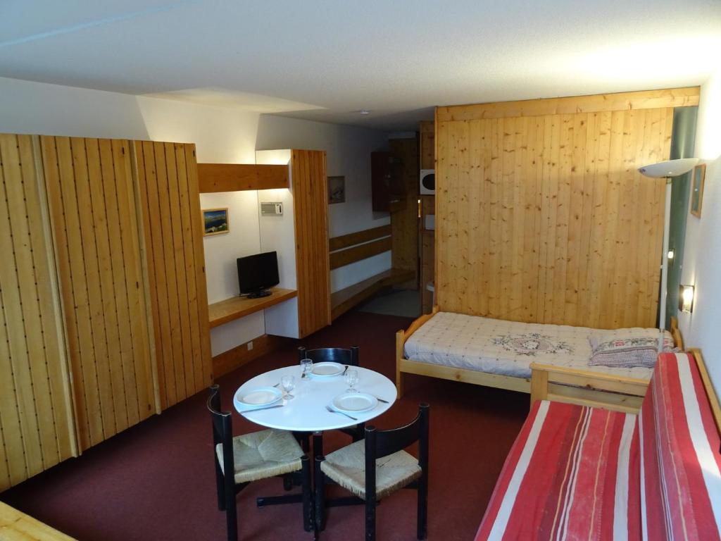 Cette petite chambre comprend une petite table et un lit. dans l'établissement Studio cosy 3 pers à Arc 1600 - Ski aux pieds, proche commerces, balcon Sud, parking et Wifi inclus - FR-1-411-421, à Arc 1600