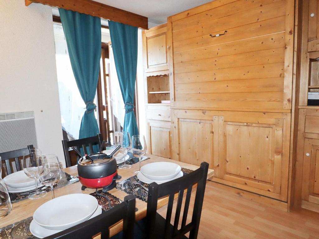 una sala da pranzo con tavolo e parete in legno di Studio Samoëns, 1 pièce, 4 personnes - FR-1-624-106 a Samoëns