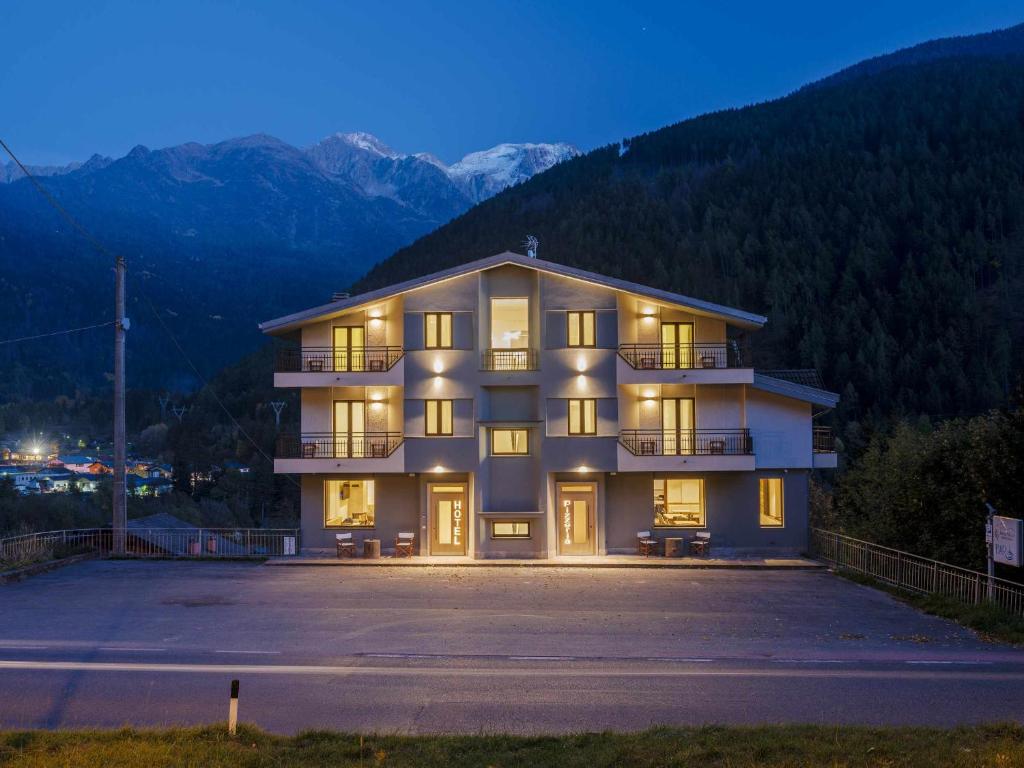 a large apartment building with a large parking lot at Hotel Garnì Alta Valle in Ponte di Legno