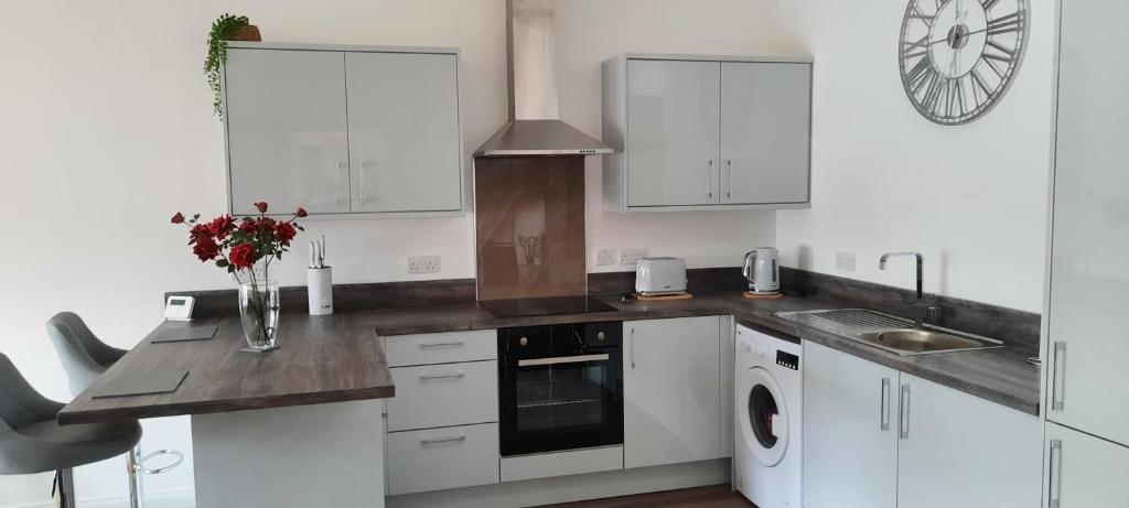 a kitchen with white cabinets and a counter top at Immaculate 1-Bed Apartment in Lanarkshire in Larkhall