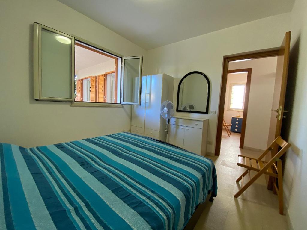 1 dormitorio con cama, espejo y puerta en Appartamento casa mare, en Alcamo Marina
