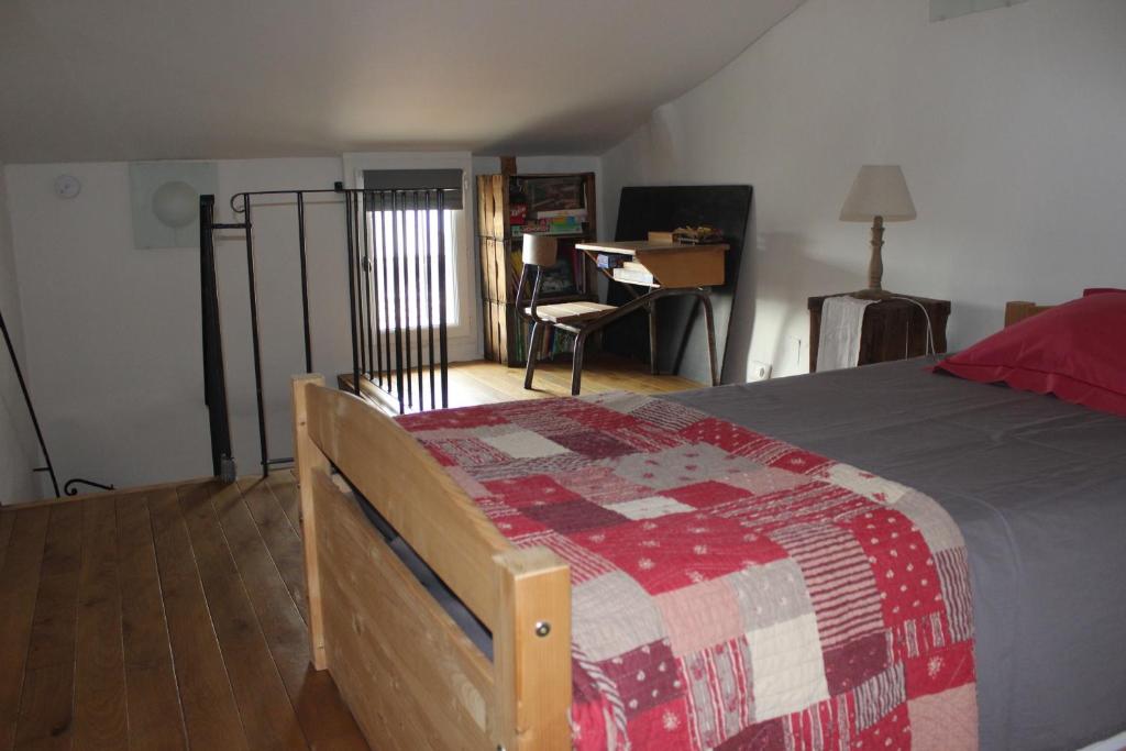 sypialnia z łóżkiem i biurkiem w pokoju w obiekcie Duplex- Isle sur Sorgue w mieście LʼIsle-sur-la-Sorgue