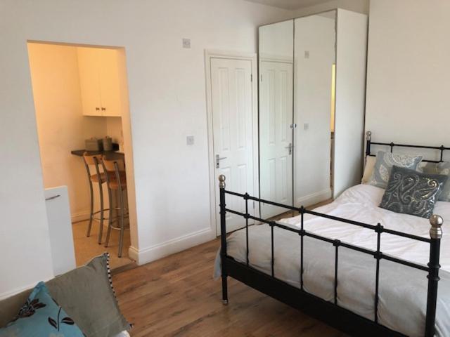 1 dormitorio con 1 cama y 1 silla en Self-contained Studio near Heathrow - 77VFR1 en Cranford