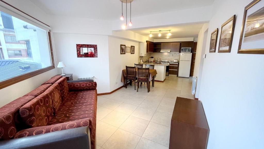 a living room with a couch and a kitchen at Apartamentos del Centro - BARILOCHE in San Carlos de Bariloche