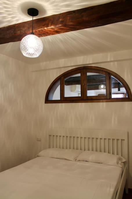sypialnia z łóżkiem z oknem i sufitem w obiekcie Cute Apartment Near Santa Croce we Florencji