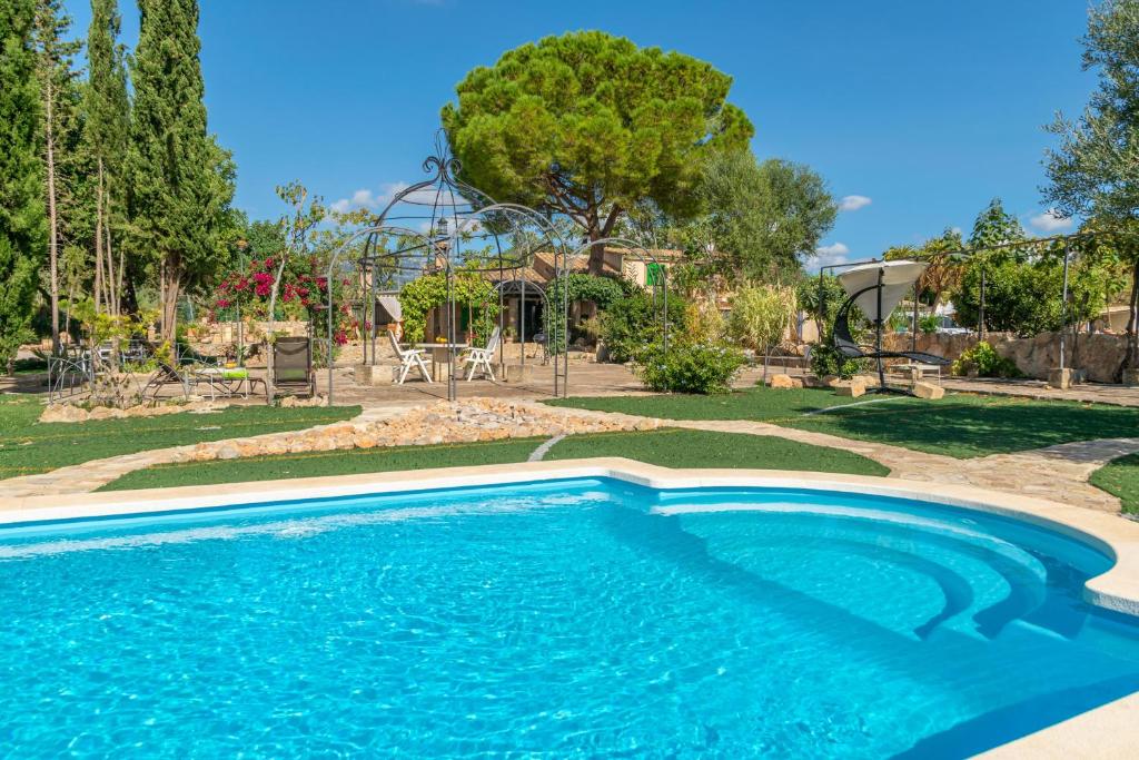 uma piscina num quintal com parque infantil em Sa Caseta -Ca n'Andreu- em Santa Maria del Camí