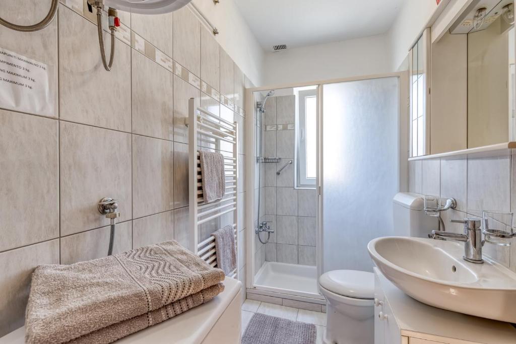 łazienka z umywalką, toaletą i prysznicem w obiekcie Apartments Azra w Puli