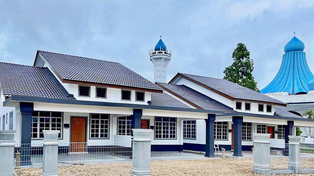 a building with a mosque in the background at NAZZA Homestay Besut with Swimming Pool in Kampung Raja