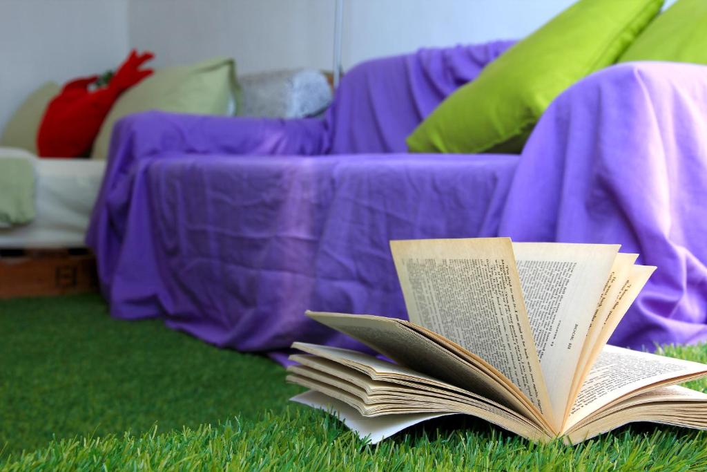 una pila di libri seduti sull'erba vicino a un divano di WonderOcean Dive Hostel a Città Vecchia di Hengchun