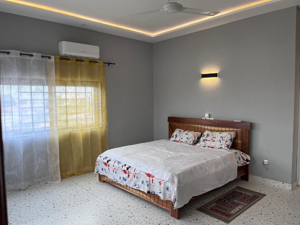 a bedroom with a bed and a window at Les Résidences de Gorée in Cotonou