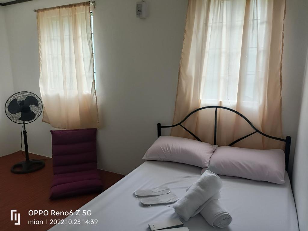 ein Schlafzimmer mit einem Bett mit lila und weißen Kissen in der Unterkunft LJ's transient house Northridge Grove, Bria Homes, Tungkong Mangga, SJDM in Santo Cristo