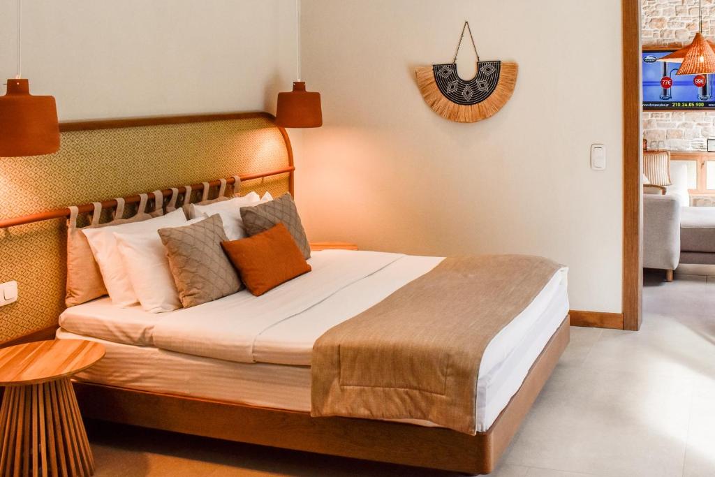 a bedroom with a large bed with orange pillows at Mandraki Village Boutique Hotel in Koukounaries