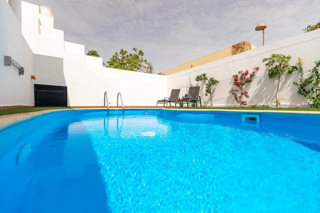 a swimming pool in front of a house at Casa Armonia - Private Pool near the Beach in Corralejo