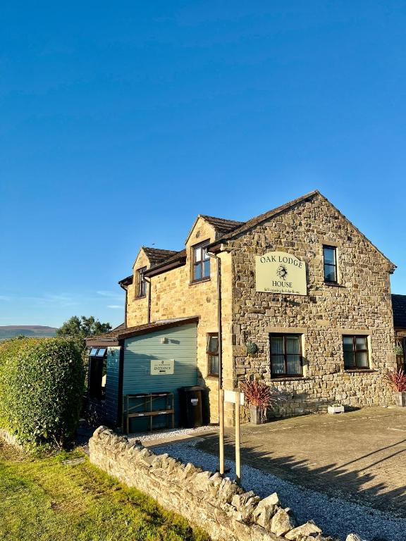 a stone building with a sign in front of it at Oaklodge House in Leyburn