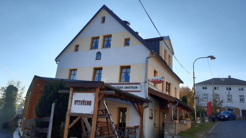 um edifício branco com um sinal em frente em Resort Abertham - penzion Ellen em Abertamy