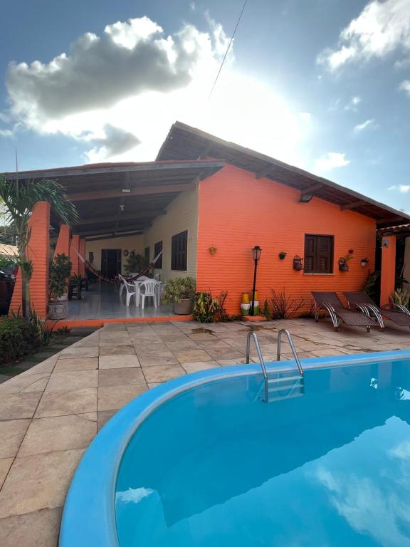 a villa with a swimming pool in front of a house at Casa de Férias no Porto das Dunas in Aquiraz