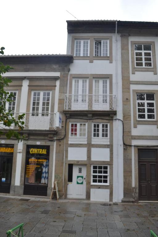 a large brick building with white windows and balconies at Arcanjo Hostel 2 in Braga