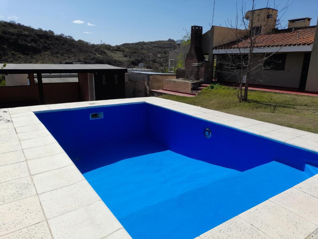 a blue swimming pool on top of a house at ESTANCIA VIEJA (CARLOS PAZ) in Estancia Vieja