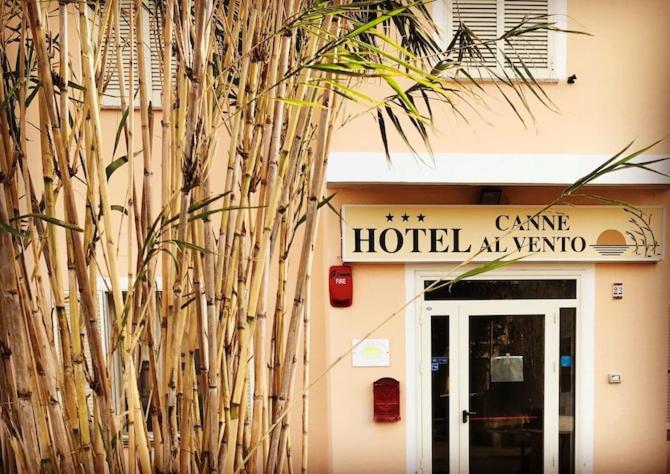 une entrée d'hôtel avec un panneau sur un bâtiment dans l'établissement Hotel Canne al Vento, à Santa Teresa Gallura