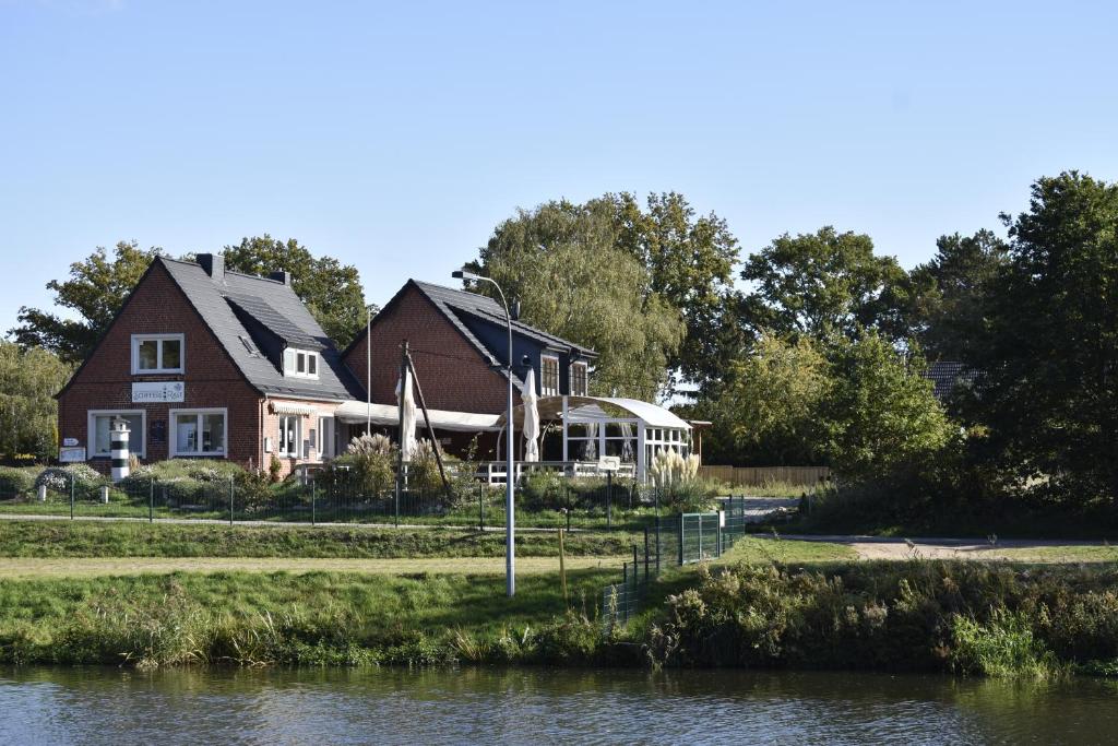 una casa junto a un cuerpo de agua en Pension zur Schleuse am Elbe Lübeck - Kanal in Witzeeze en Witzeeze