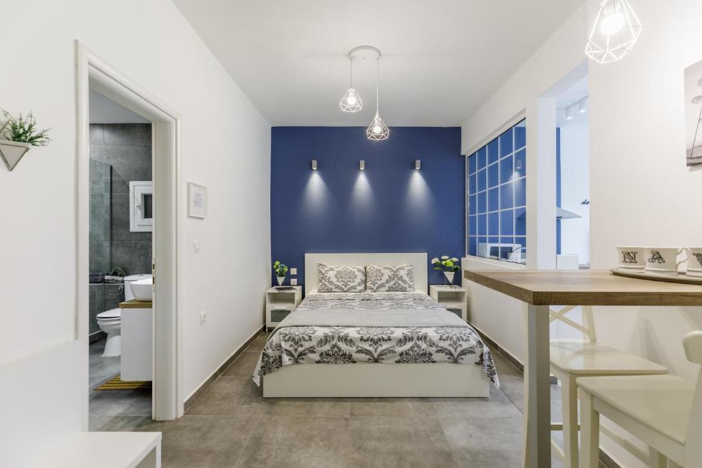 1 dormitorio con cama y pared azul en NAVA Apartment in the center of Thessaloniki en Tesalónica