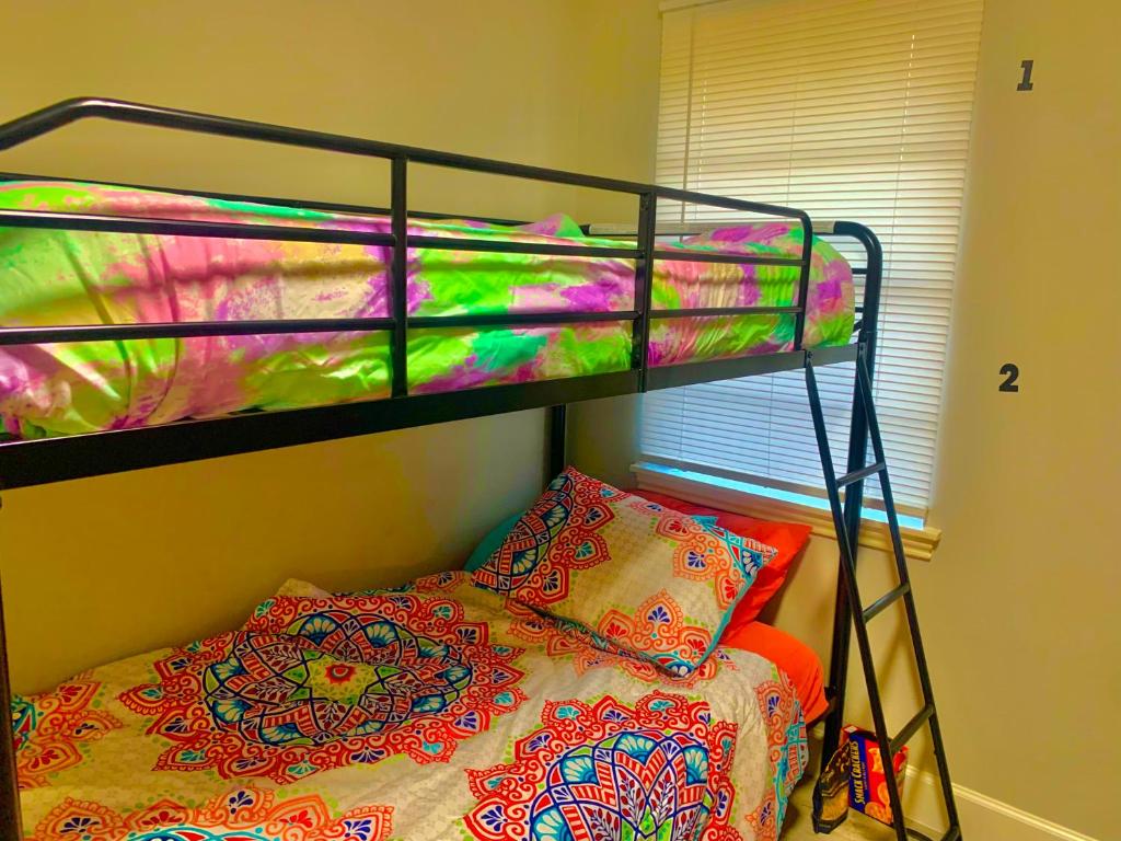 a bedroom with a bunk bed with a colorful blanket at The Ugly House in Houston
