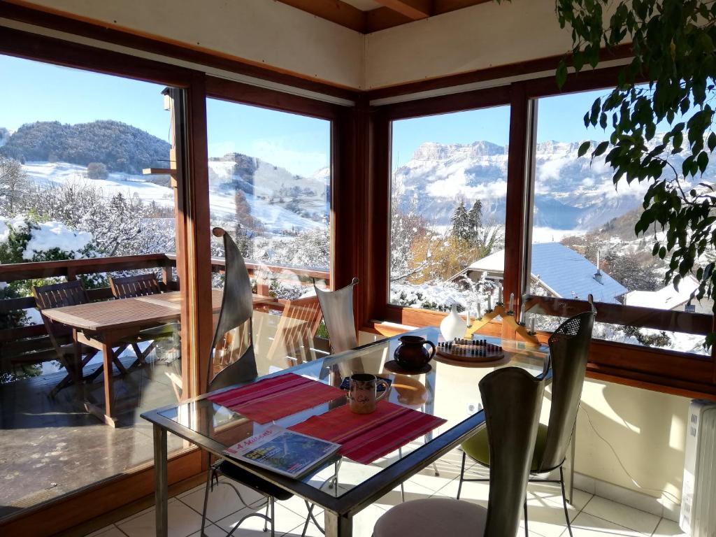 a dining room with a table and a view of mountains at Eco-Logis Mad'in Belledonne in Theys