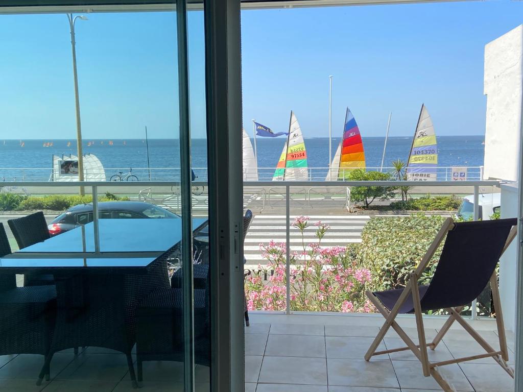 a dining room with a view of sailboats in the water at Appartement face mer LA BAULE in La Baule