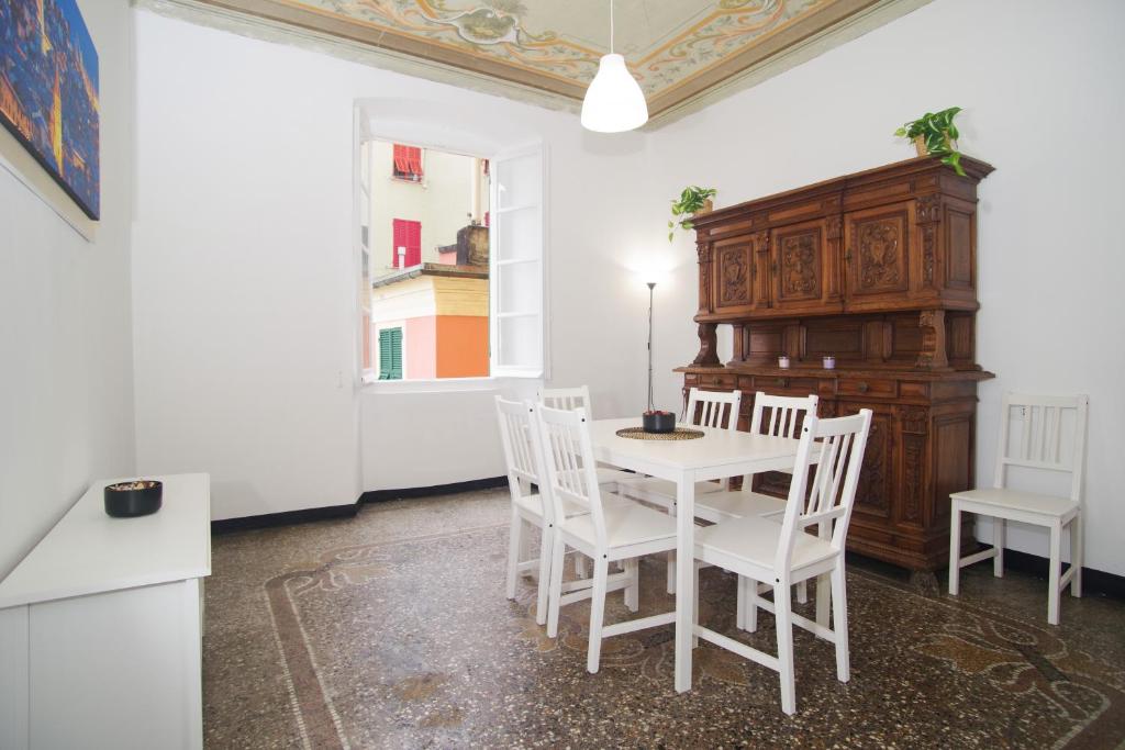 ein weißes Esszimmer mit einem Tisch und Stühlen in der Unterkunft CASA Candida in Genua